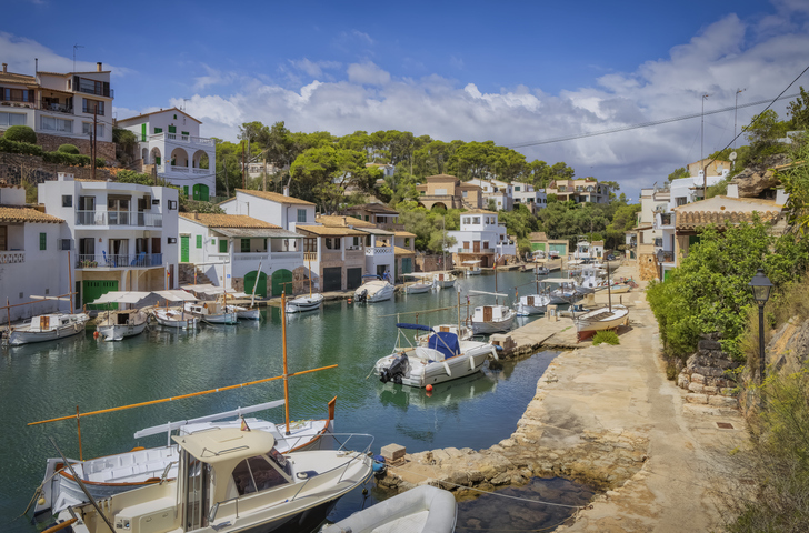Panoramaaufnahme vom idyllischen Hafen in Cala Figuera mit traditionellen Bootshäusern und Fischerbooten
