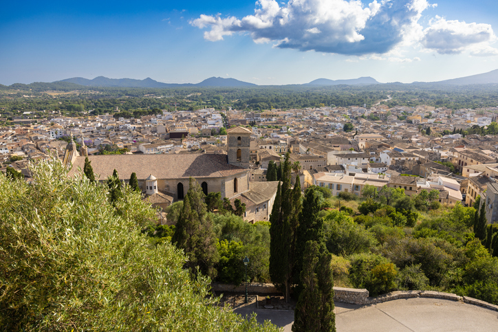 Panoramablick auf Artà auf Mallorca mit der Kirche Transfiguració del Senyor im Vordergrund und der Serra de Llevant im Hintergrund.