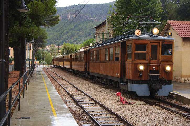Historischer Holzzug des Tren de Sóller steht am Bahnsteig im Bahnhof von Sóller auf Mallorca.