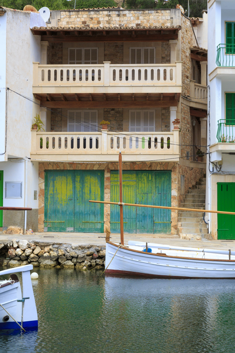 Charakteristische Bootshäuser mit bunten Holztoren am Wasser in Cala Figuera, Mallorca