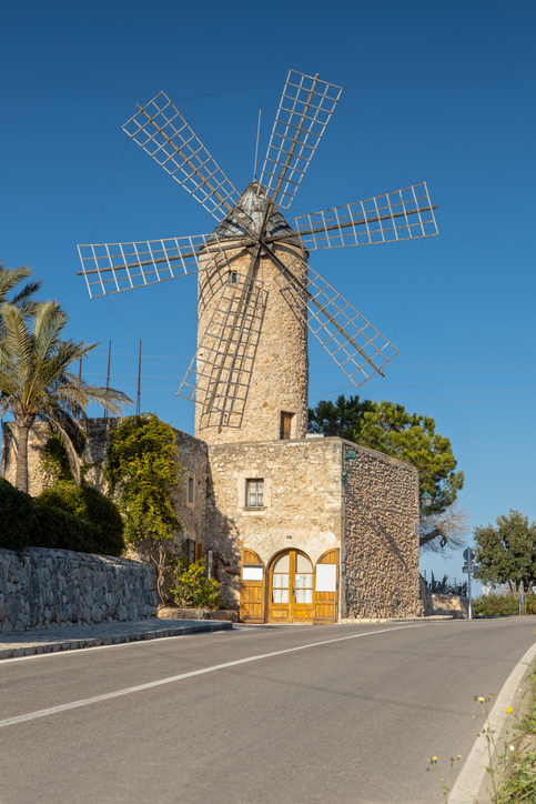 Traditionelle mallorquinische Windmühle aus Naturstein an einer Straße in Sineu