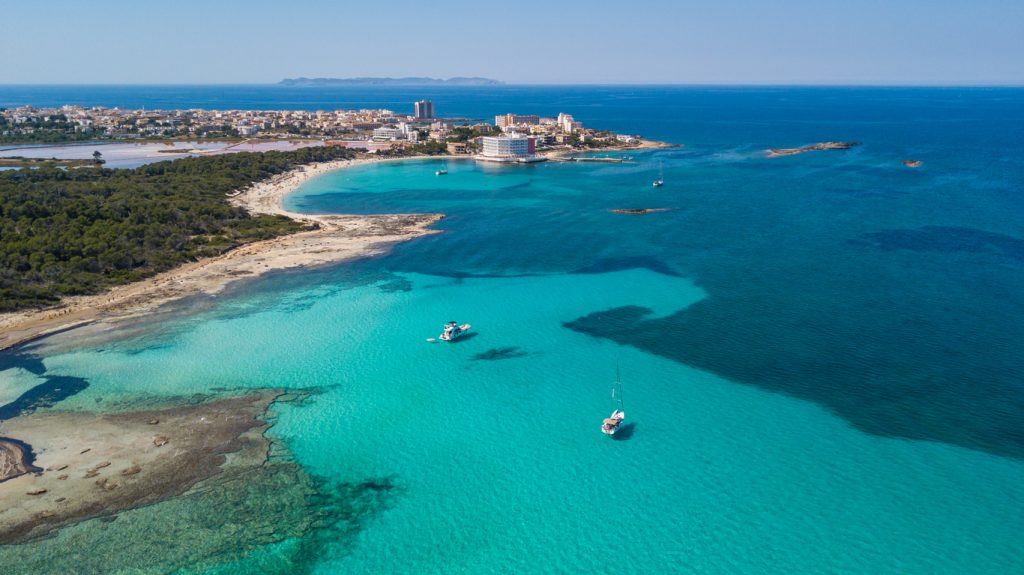 Luftaufnahme der Colònia de Sant Jordi mit kristallklarem Wasser, Booten und Küstenlinie auf Mallorca
