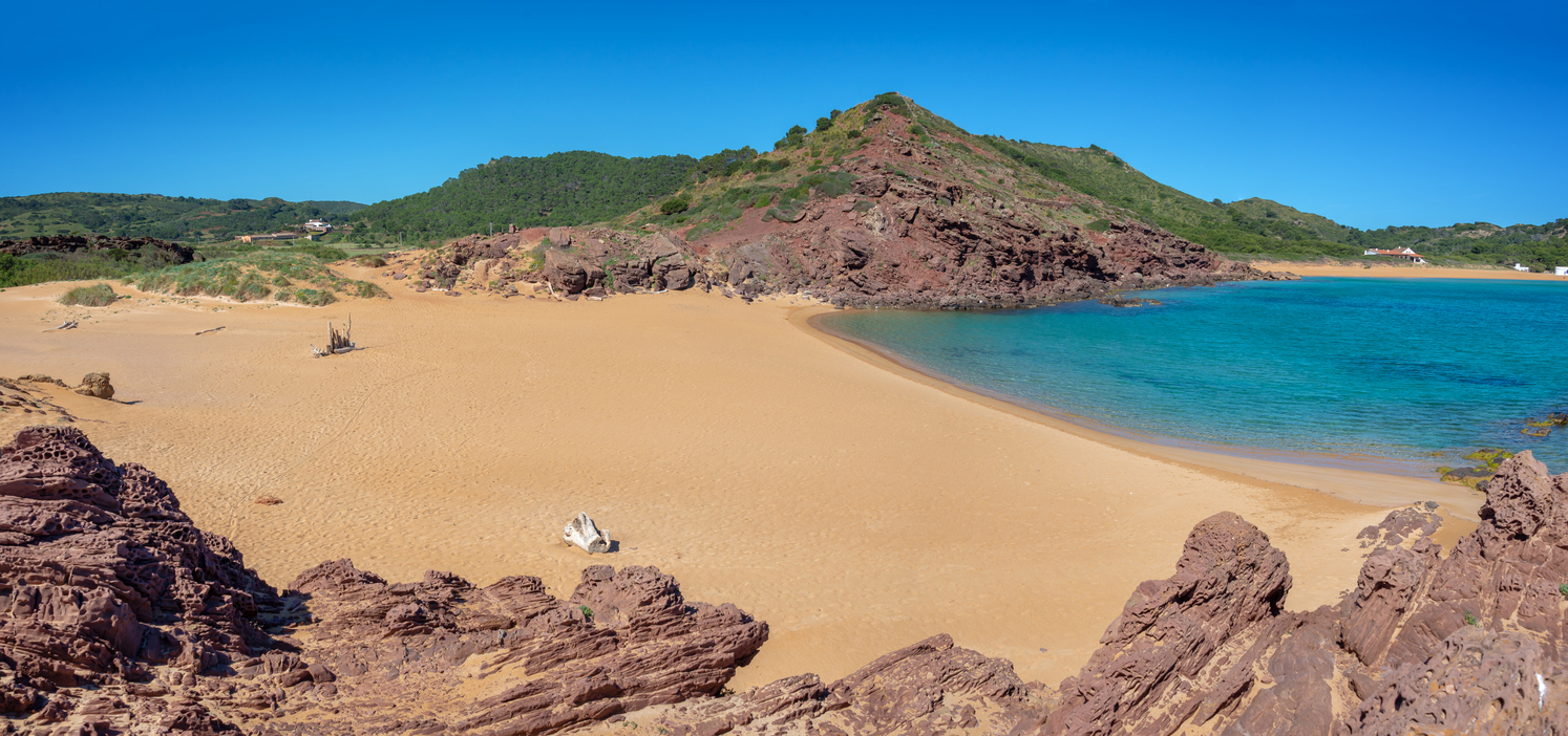 Cala Pregonda – naturbelassene Bucht mit rotem Sand, Felseninseln und glasklarem Wasser auf Menorca