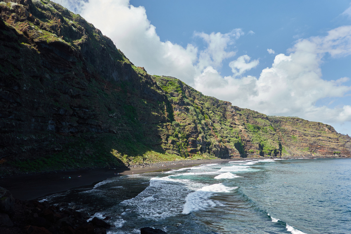 Schwarzer Sandstrand Playa de Nogales mit grüner Steilküste und Atlantikwellen auf La Palma