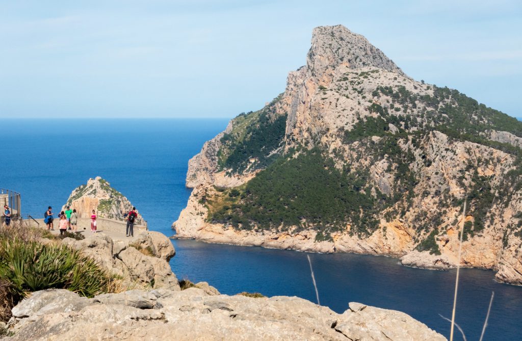Touristen genießen die spektakuläre Aussicht vom Mirador de El Colomer auf das Cap Formentor und das tiefblaue Meer