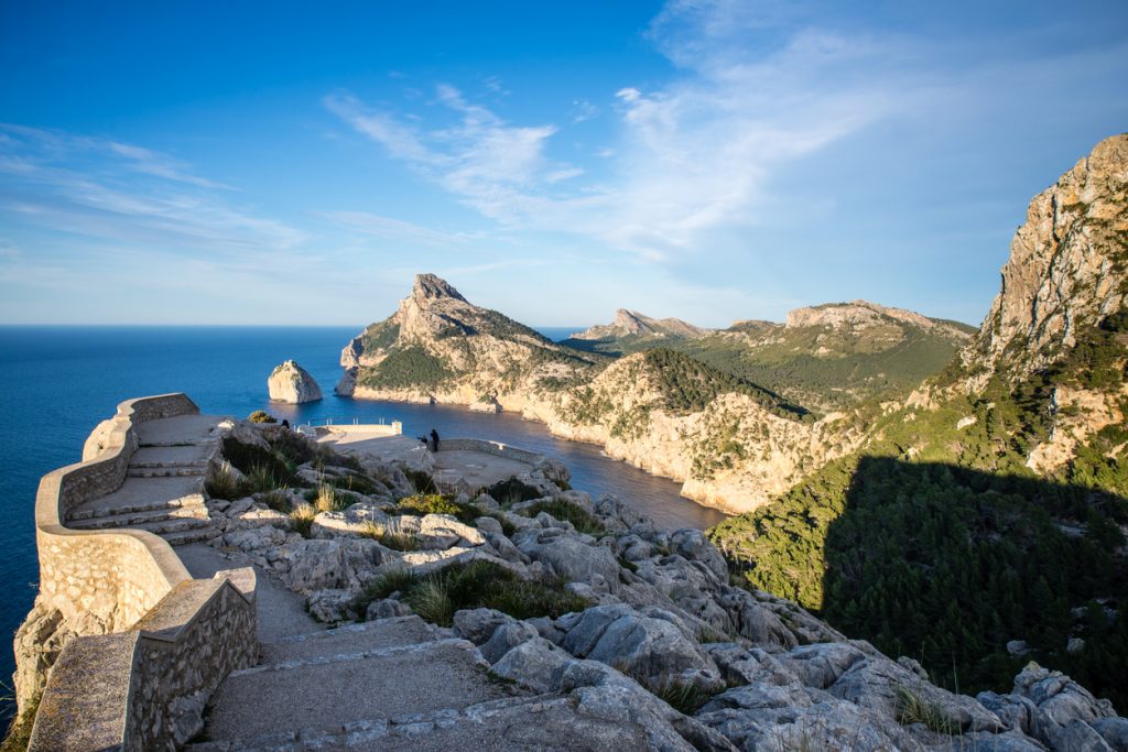 Blick von der Aussichtsplattform Mirador Es Colomer auf die felsige Küste und das tiefblaue Meer im Norden Mallorcas bei klarem Himmel.