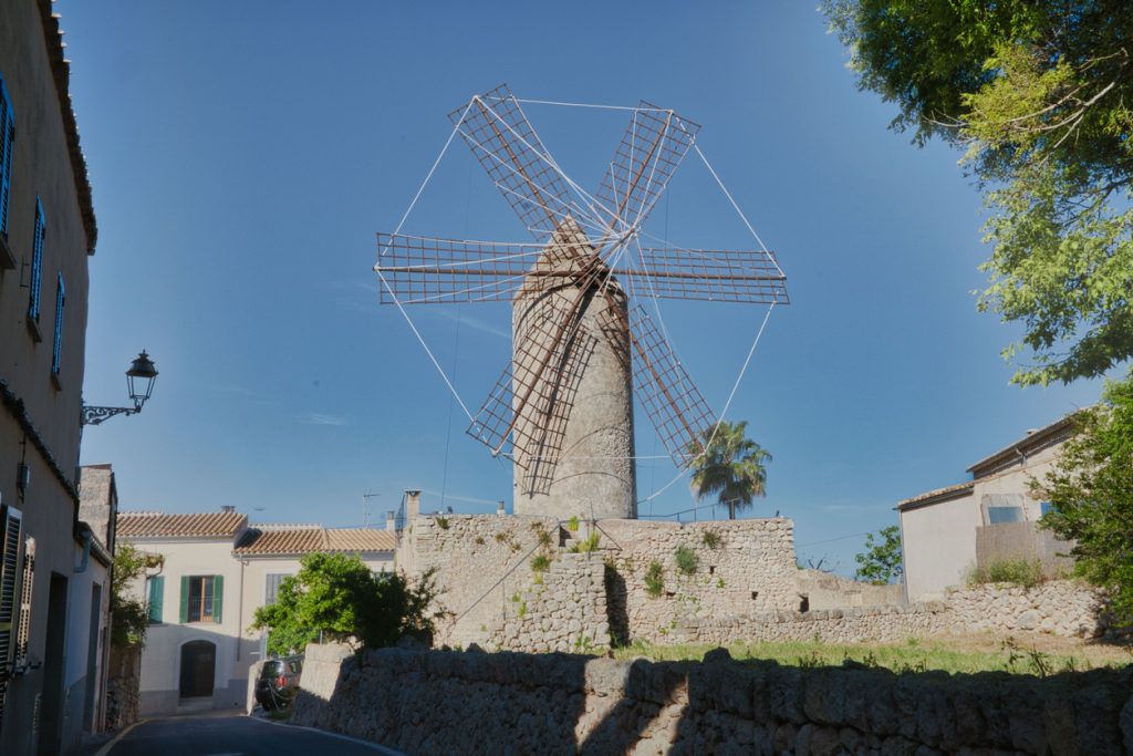 Traditionelle mallorquinische Windmühle mit Steinmauer im Zentrum des Dorfes Costitx
