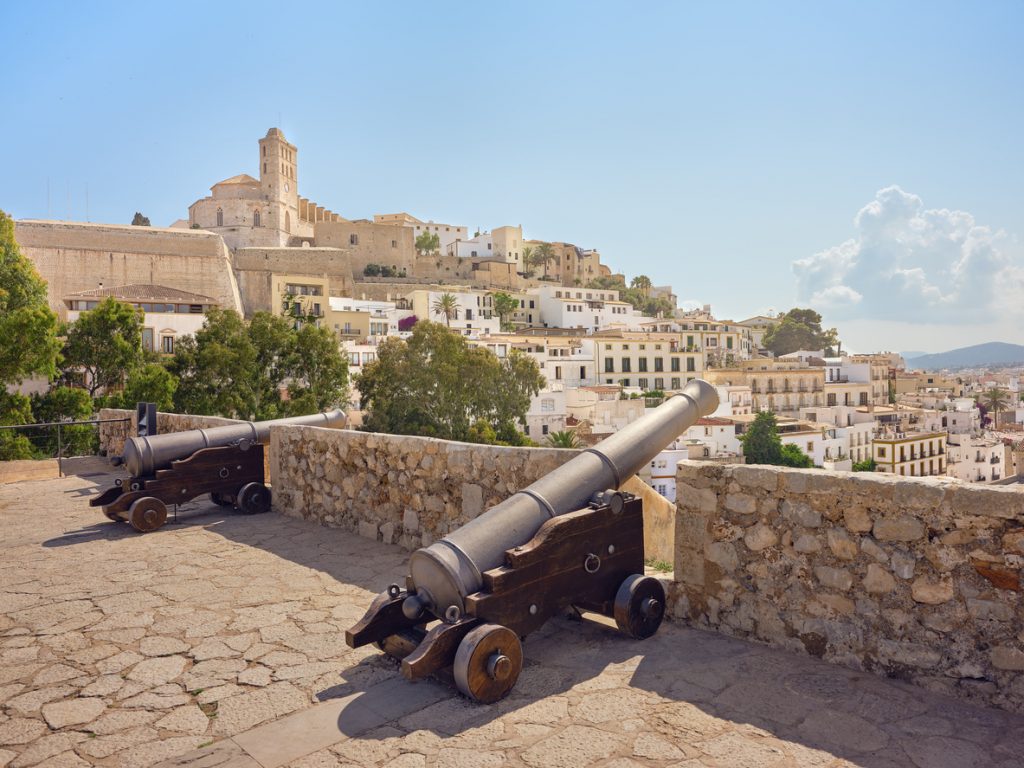 Alte Kanonen auf der Festungsmauer von Dalt Vila mit Blick auf die Altstadt und die Kathedrale von Eivissa auf Ibiza.