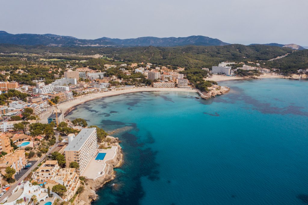 Luftaufnahme von Peguera auf Mallorca mit Hotels, Sandstrand und türkisblauem Meer.