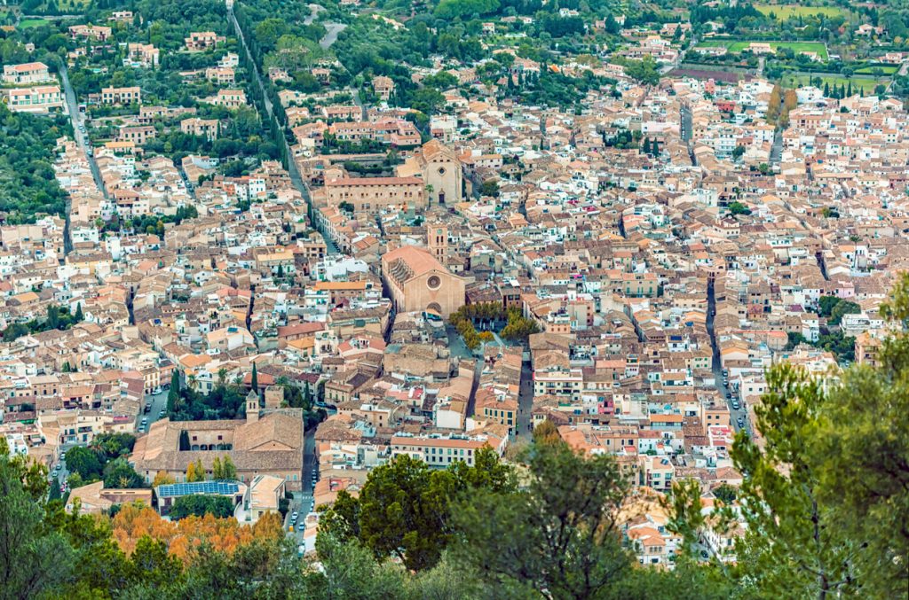 Luftaufnahme der mallorquinischen Stadt Pollença mit historischer Bebauung und zentraler Kirche auf der Insel Mallorca