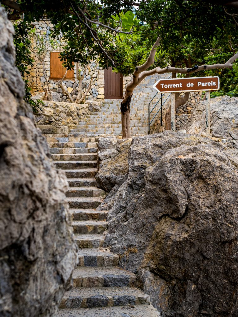 Steintreppe in Port de Sa Calobra auf Mallorca mit Wegweiser zur Schlucht Torrent de Pareis.