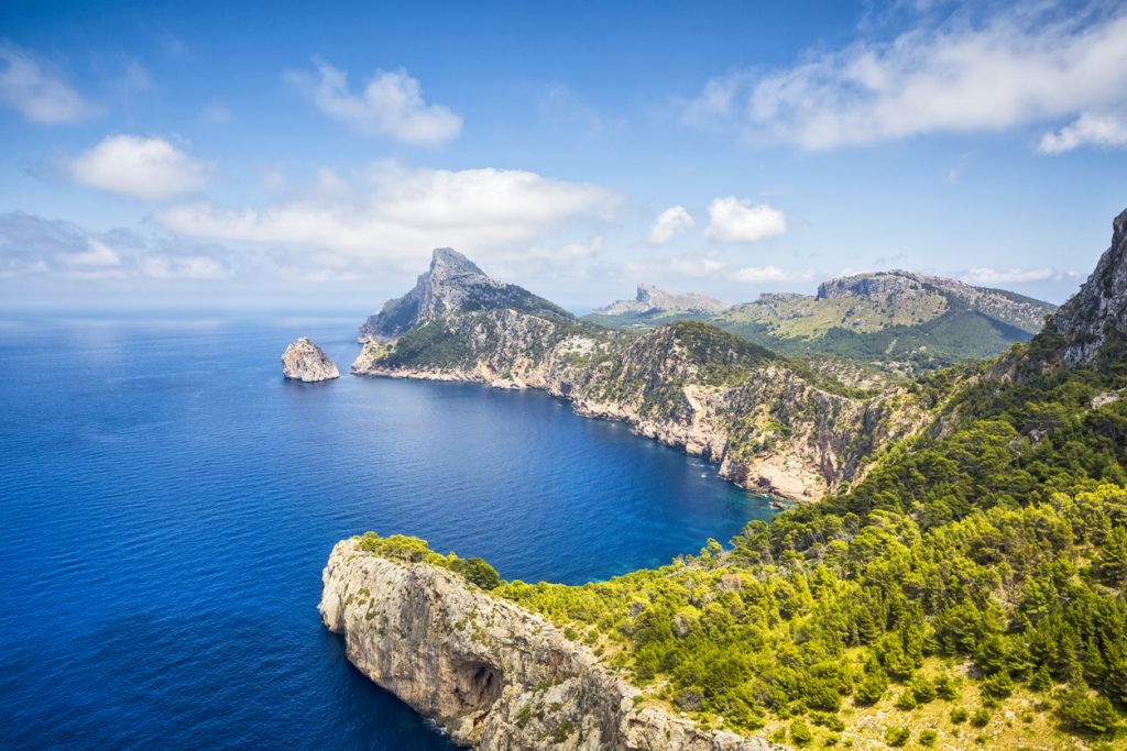 Panoramablick vom Aussichtspunkt Mirador de El Colomer über die zerklüftete Nordwestküste Mallorcas mit türkisblauem Meer und grüner Vegetation