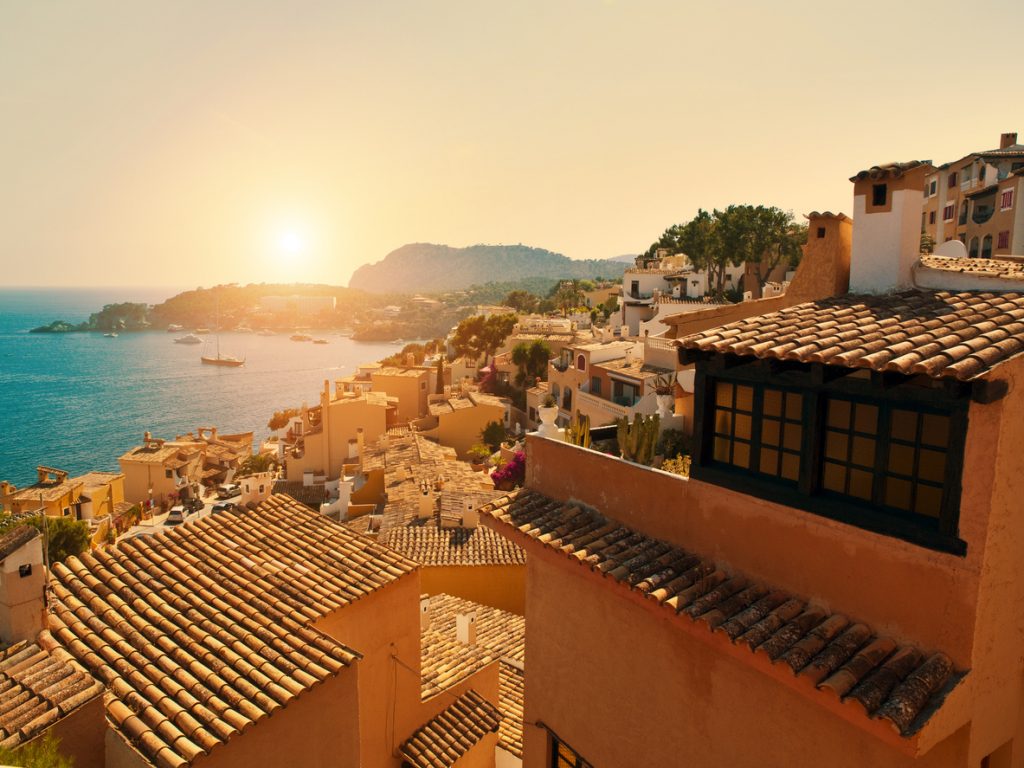 Traditionelle Häuser in Peguera auf Mallorca bei Sonnenuntergang mit Blick auf das Meer.