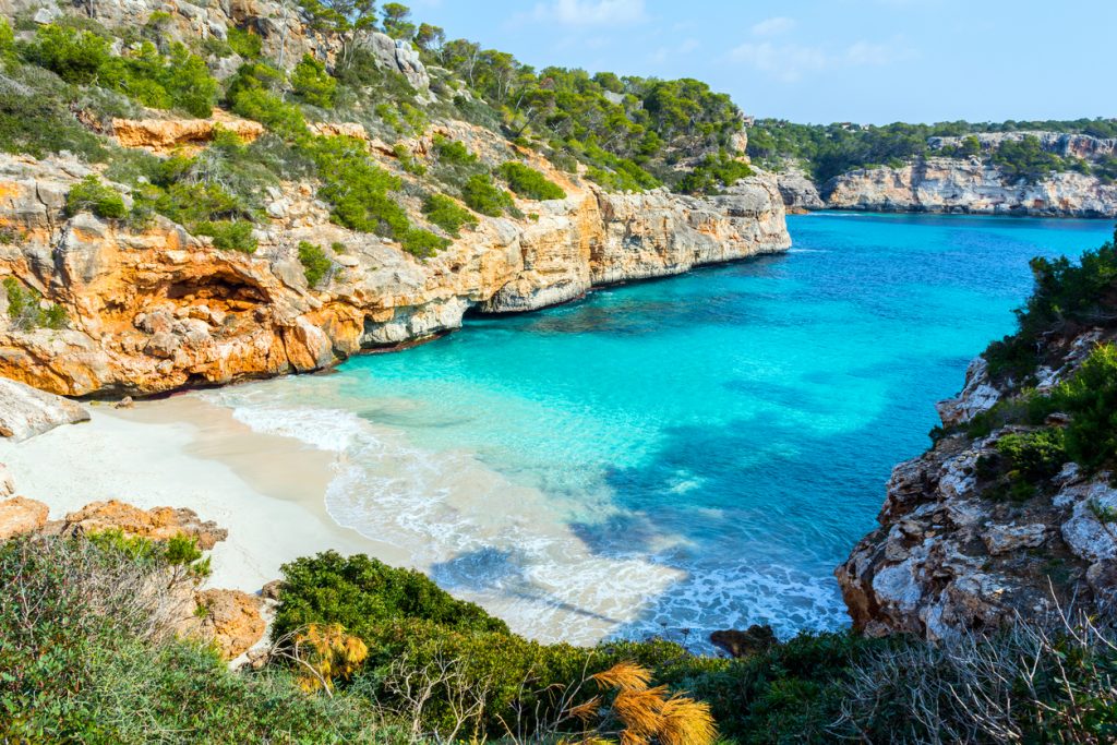 Blick auf die Bucht Caló des Moro mit feinem Sandstrand, türkisblauem Wasser und steilen Felsklippen