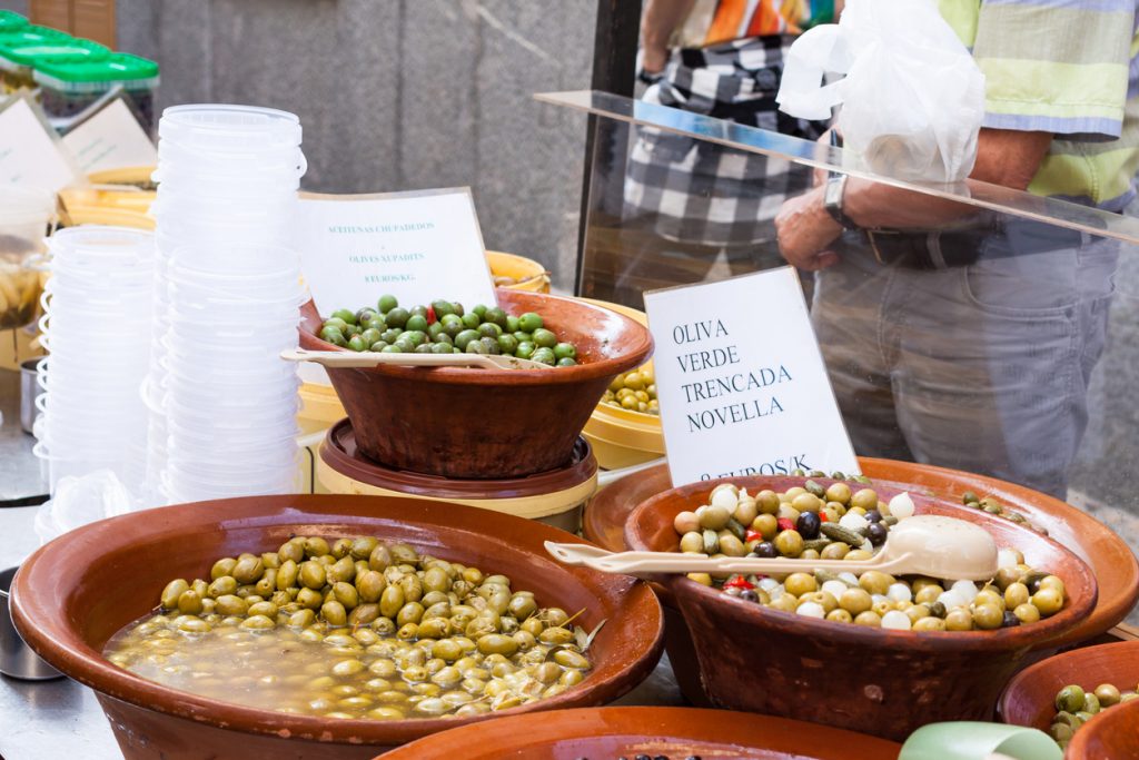 Verschiedene Sorten Oliven in Ton-Schalen auf dem Wochenmarkt in Sineu, Mallorca.