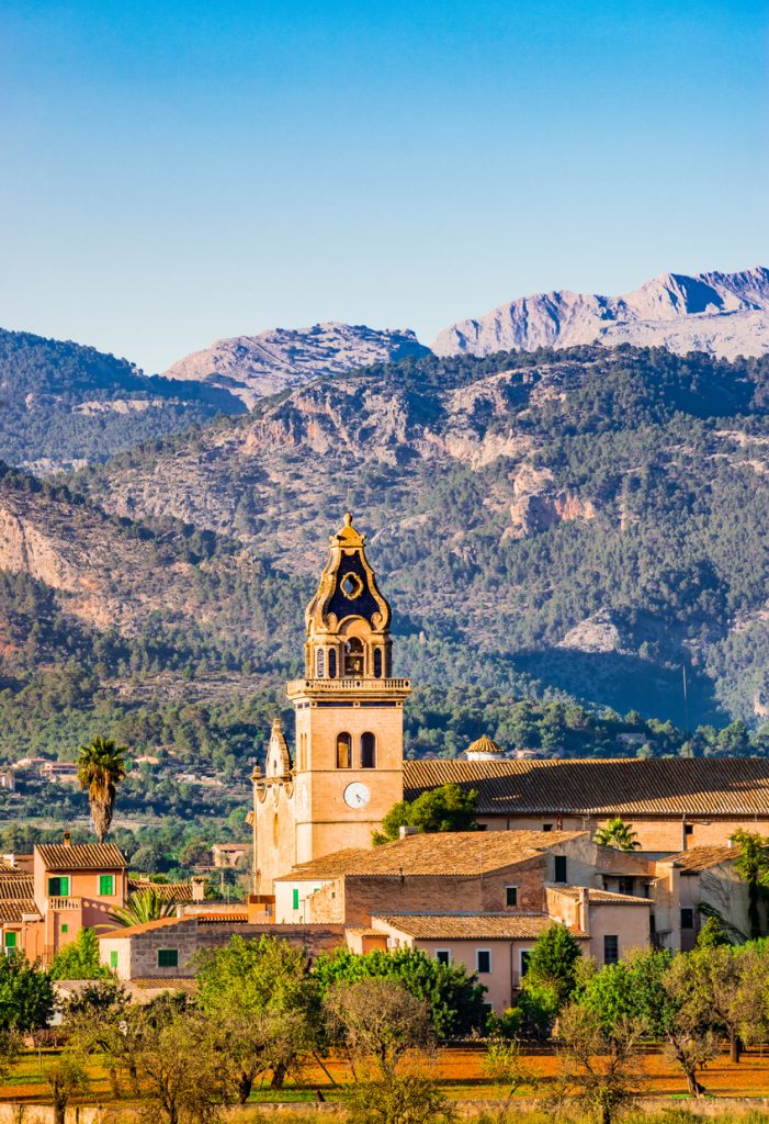 Blick auf die Kirche von Santa Maria del Camí auf Mallorca mit dem Tramuntana-Gebirge im Hintergrund.