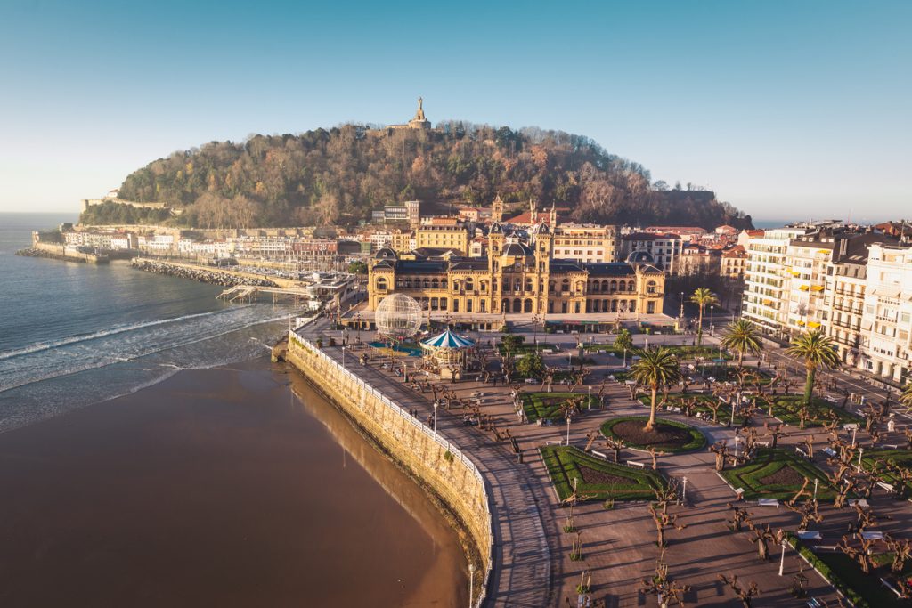 Panoramablick auf San Sebastián mit Rathaus, Strand und Monte Urgull im Hintergrund.