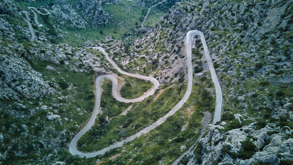 Luftaufnahme der Serpentinenstraße nach Sa Calobra (MA-2141) mit 270-Grad-Kurve in der felsigen Serra de Tramuntana, Mallorca