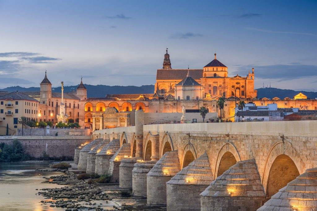 Córdoba: Mezquita-Catedral und Puente Romano über dem Guadalquivir bei Dämmerung