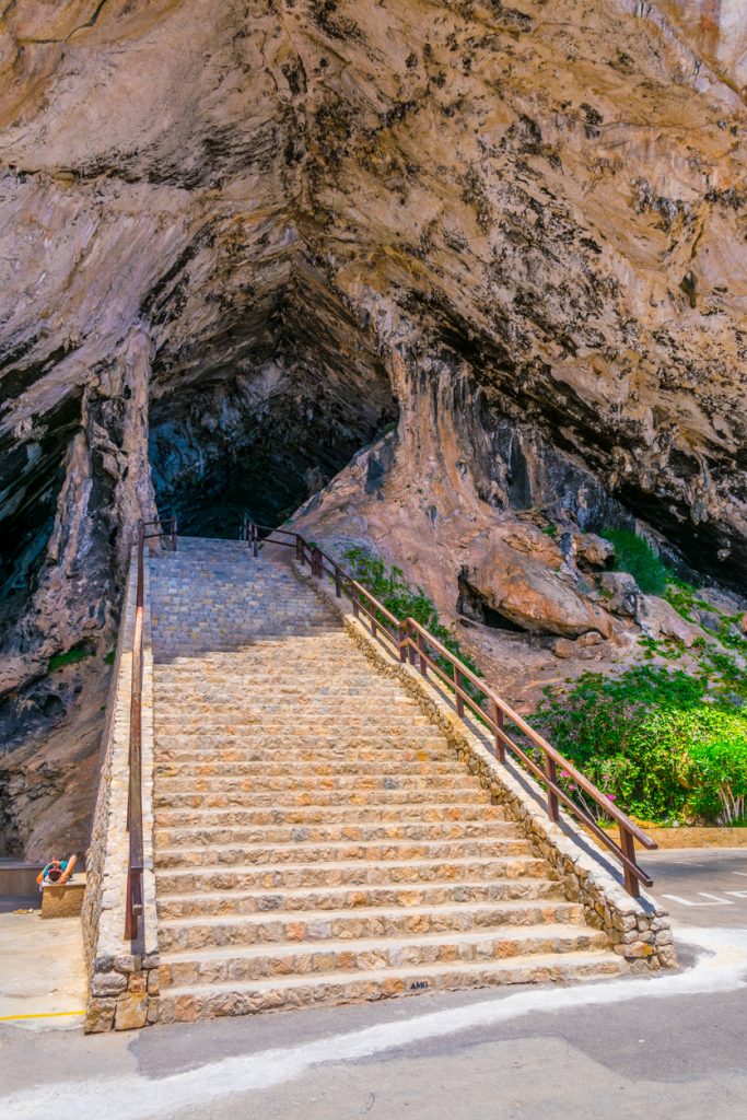 Steintreppe führt in eine große Felsgrotte auf Mallorca.