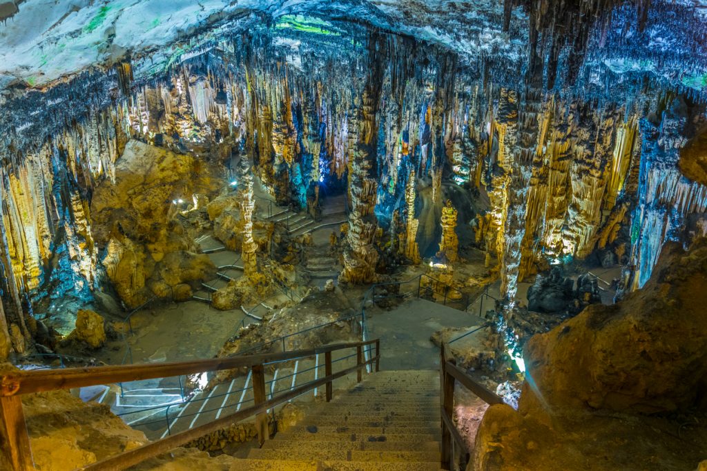 Tropfsteinhöhle mit Treppen, Stalaktiten und Stalagmiten.