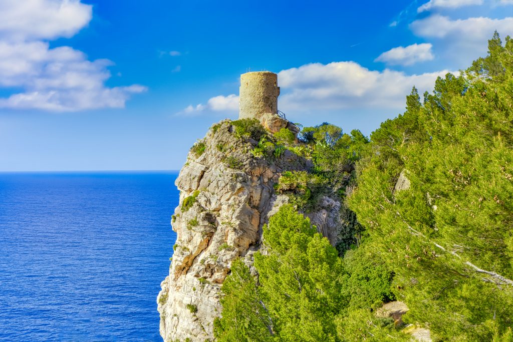 Alter Rundturm steht auf einer Felsspitze über dem Meer.