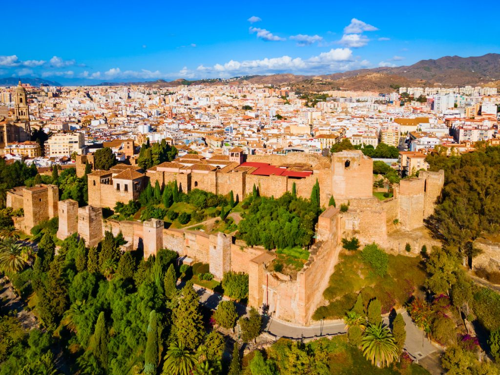 Luftaufnahme der maurischen Festung Alcazaba vor der Skyline Málagas.