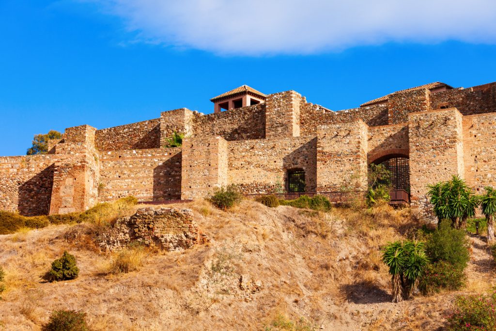 Maurische Festung Alcazaba auf einem Hügel in Málaga unter blauem Himmel.