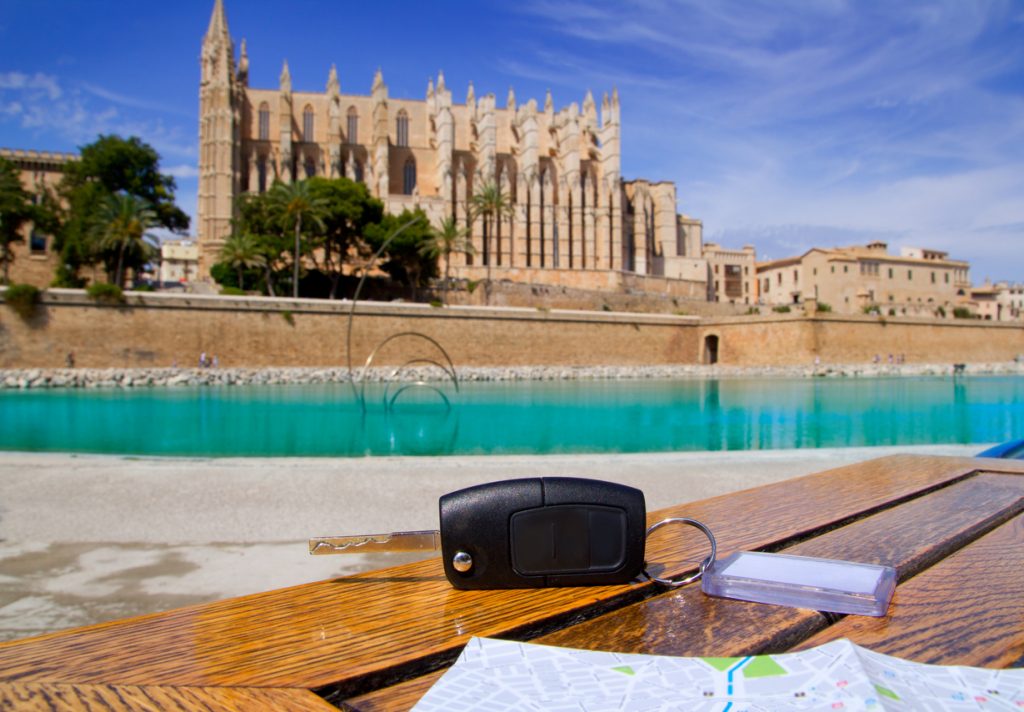 Autoschlüssel und Stadtplan liegen vor der Kathedrale La Seu in Palma de Mallorca.