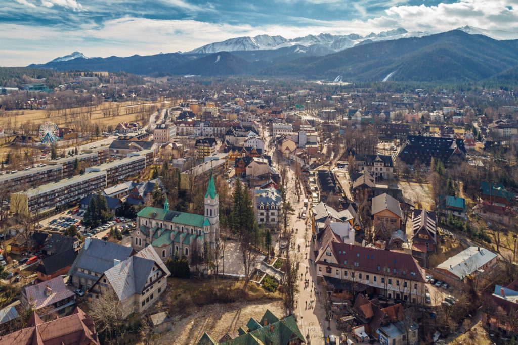 Luftbild der Stadt mit Kirche und Tatra im Hintergrund.
