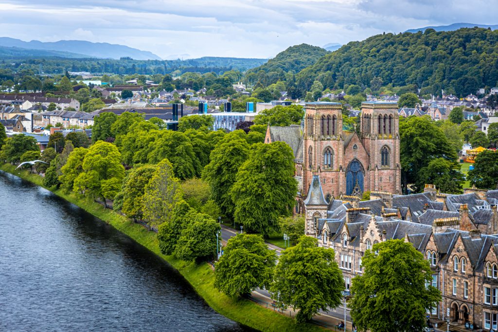Die St Andrew’s Cathedral ragt zwischen Bäumen am River Ness in Inverness.