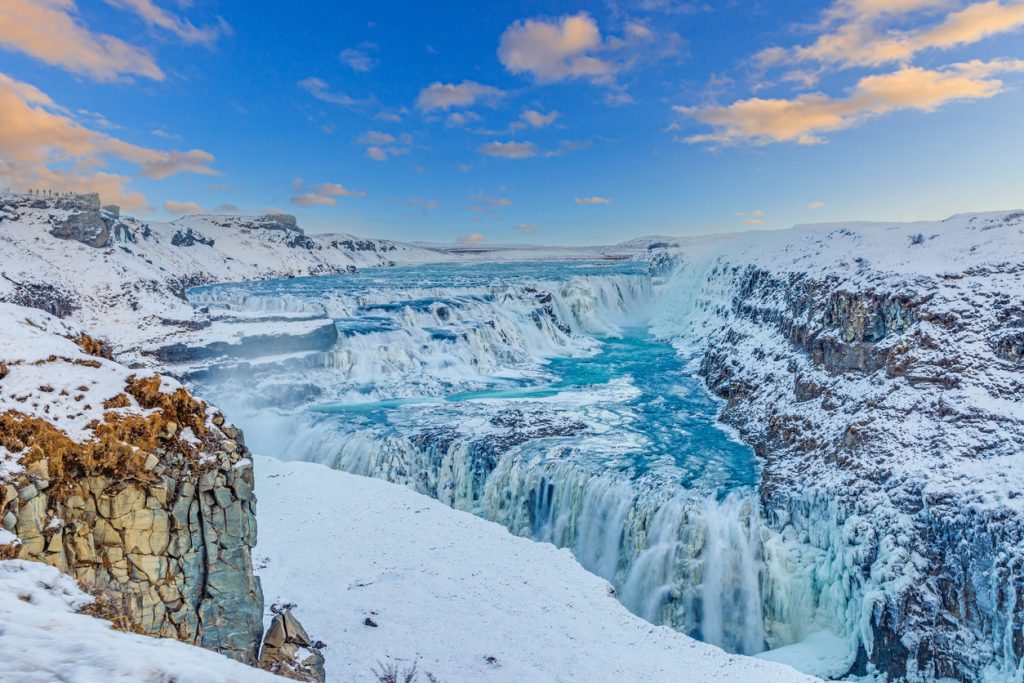 Der zweistufige Wasserfall Gullfoss stürzt in einer schneebedeckten Schlucht im Golden Circle.