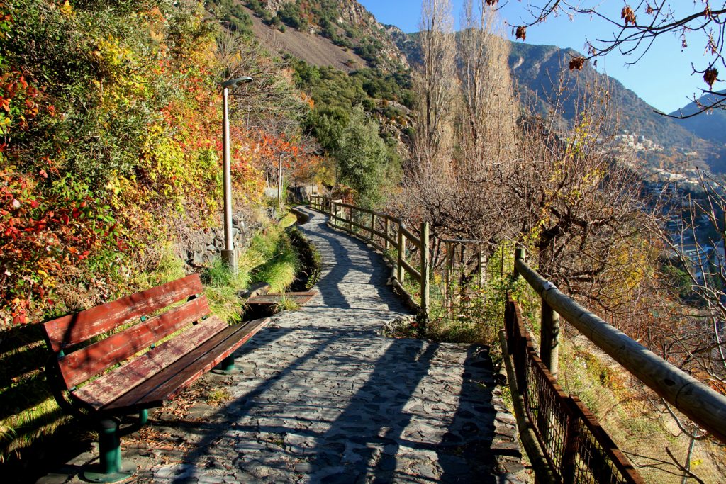 Gepflasterter Spazierweg mit Holzgeländer oberhalb der Stadt.