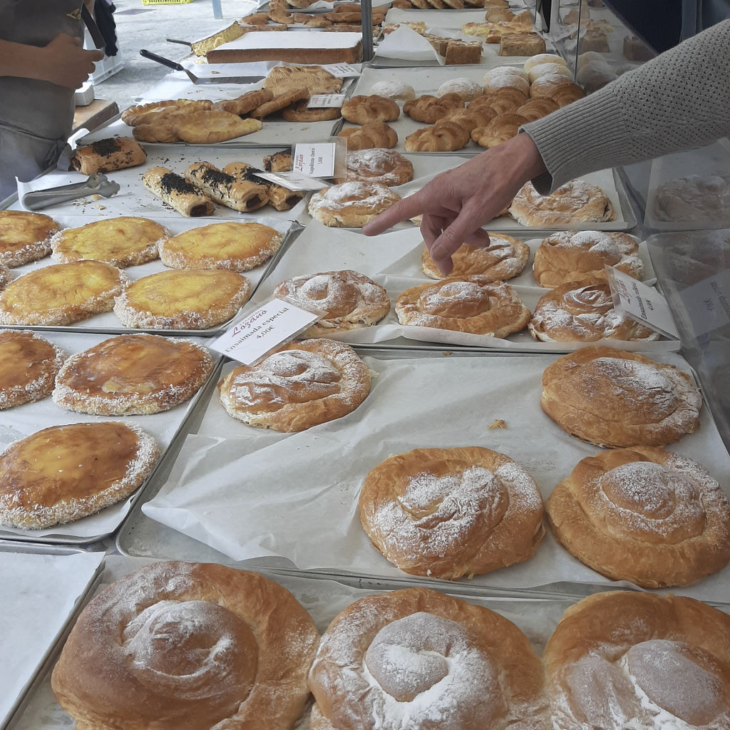 Tabletts voller spiralförmigem Hefegebäck mit Puderzucker.