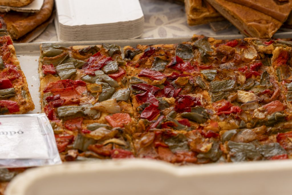 Rechteckige Gemüse-Coca mit Paprika, Zwiebeln und Tomaten.