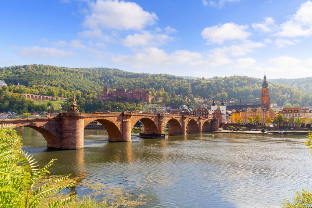 Steinbogenbrücke über den Neckar mit Heidelberger Schloss und Altstadt im Hintergrund.