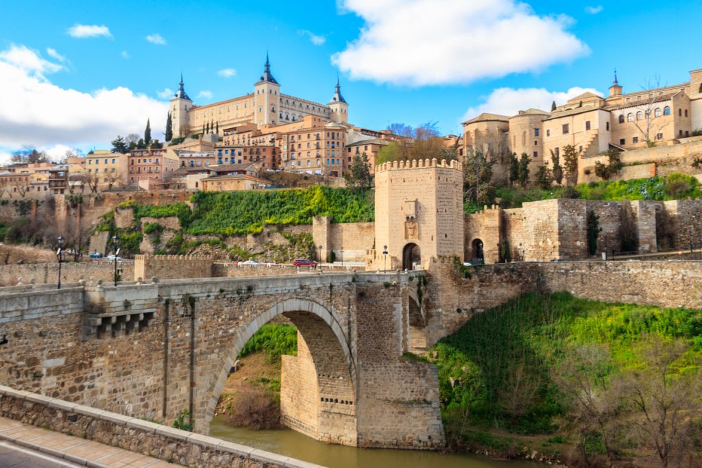Historische Steinbrücke und befestigtes Tor unterhalb des Alcázars von Toledo am Fluss Tajo.