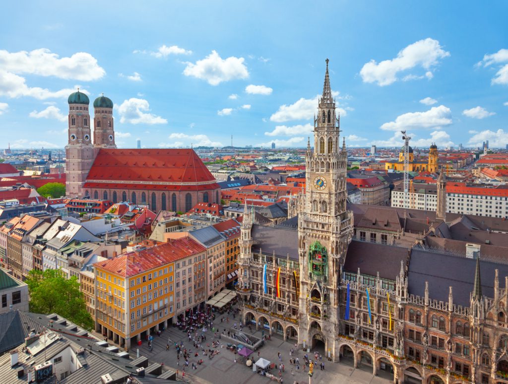 Panorama der Münchner Altstadt mit Neuem Rathaus und Frauenkirche bei blauem Himmel.