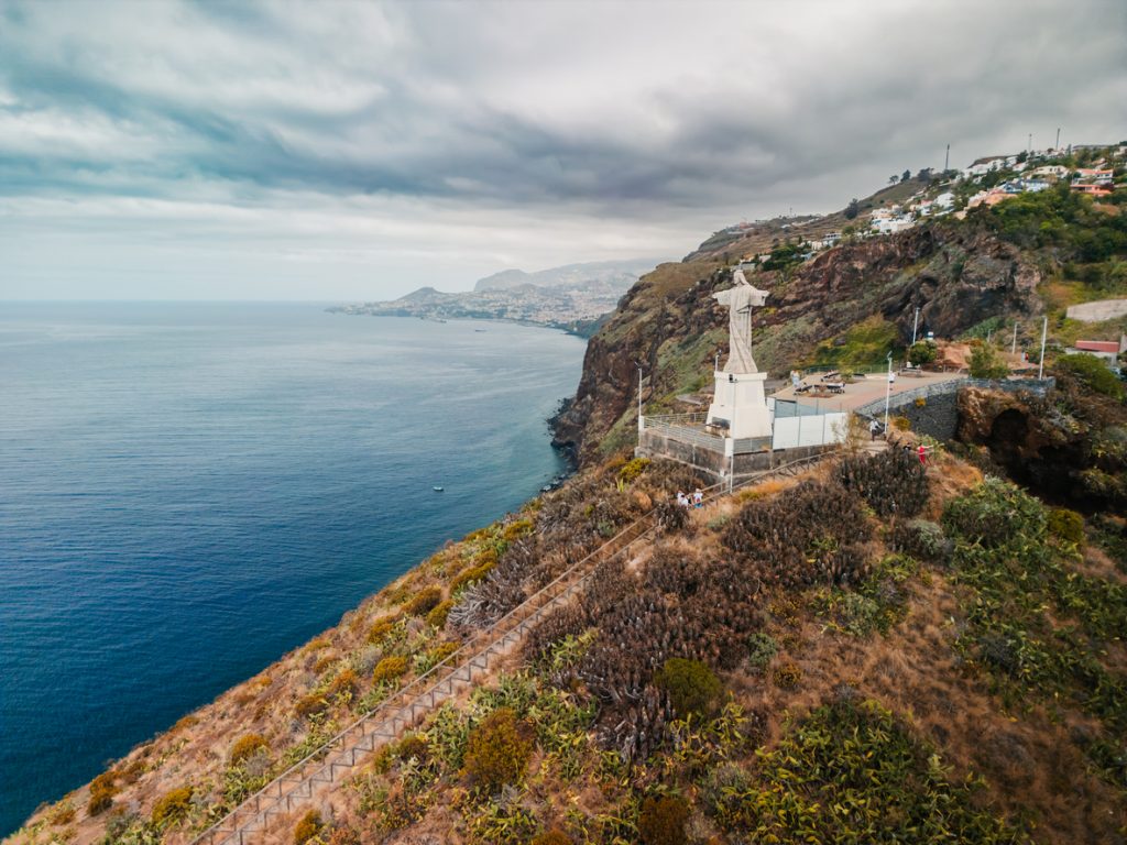 Christusstatue mit ausgebreiteten Armen steht hoch über dem Atlantik.