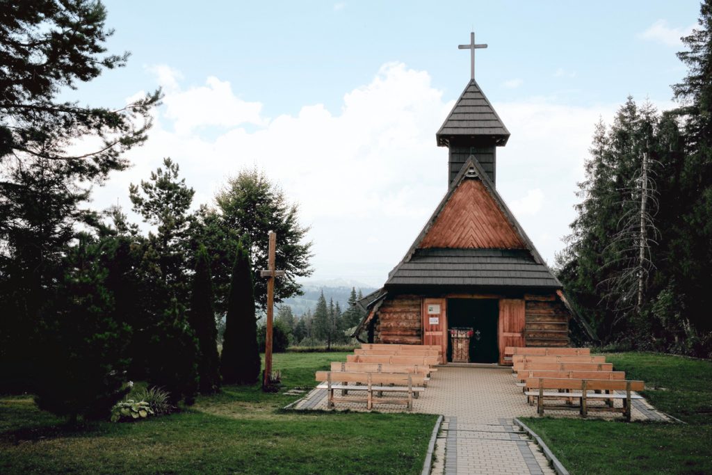 Kleine Holzkapelle mit Außenbänken im Grünen bei Zakopane.