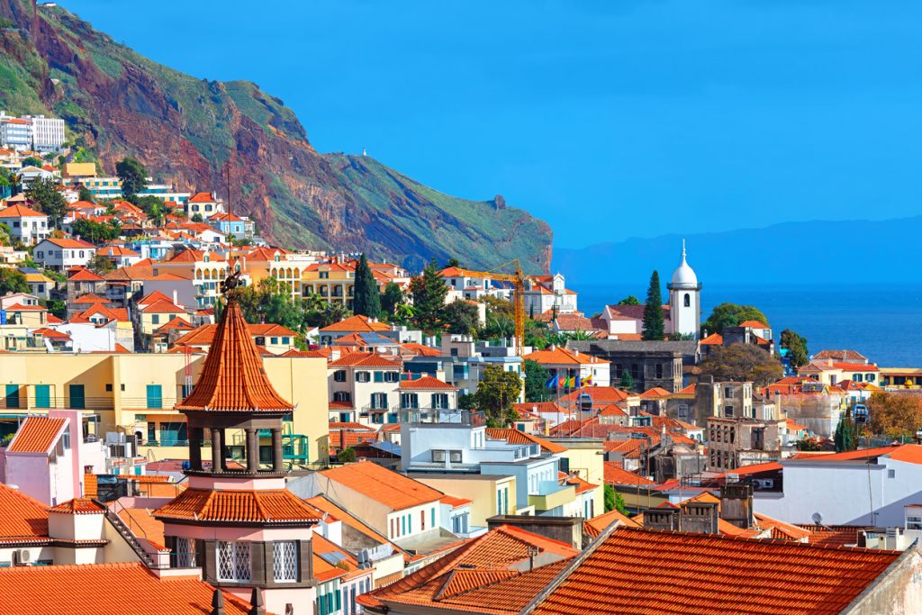 Blick über Funchals Häusermeer vor Steilküste und Atlantik.
