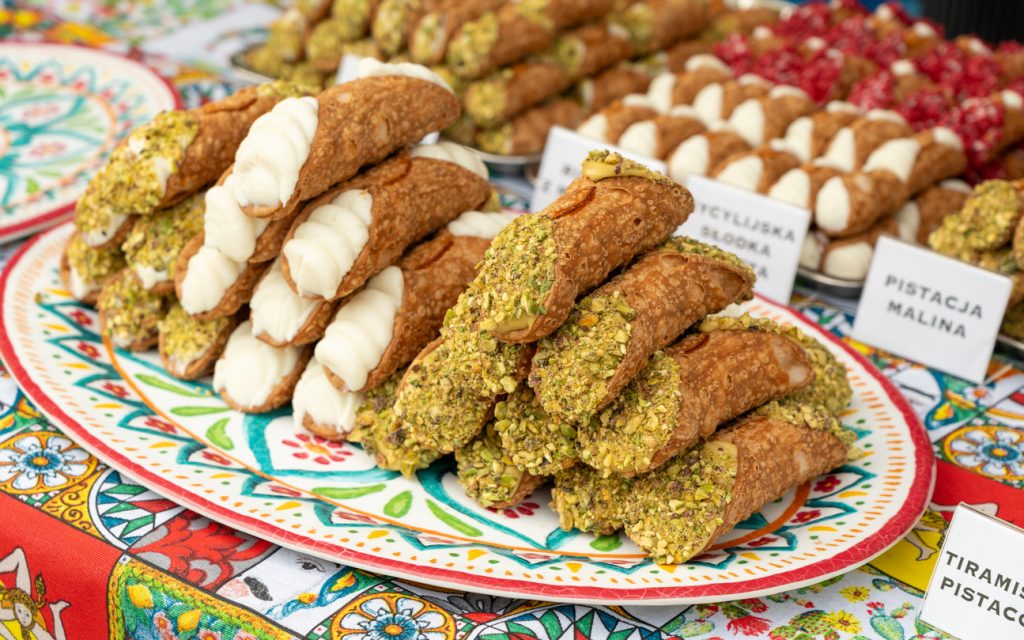 Sizilianische Cannoli mit Ricottafüllung und Pistazien auf bunter Keramik in Palermo.
