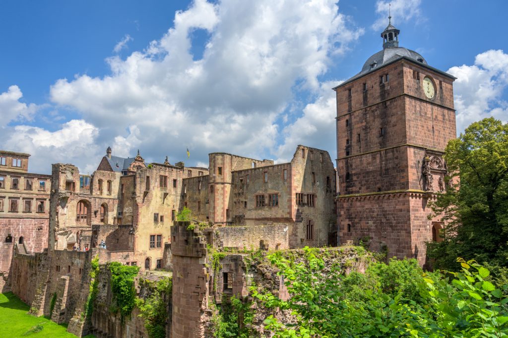 Nahaufnahme der Schlossruine mit Turm, Sandsteinmauern und viel Grün.