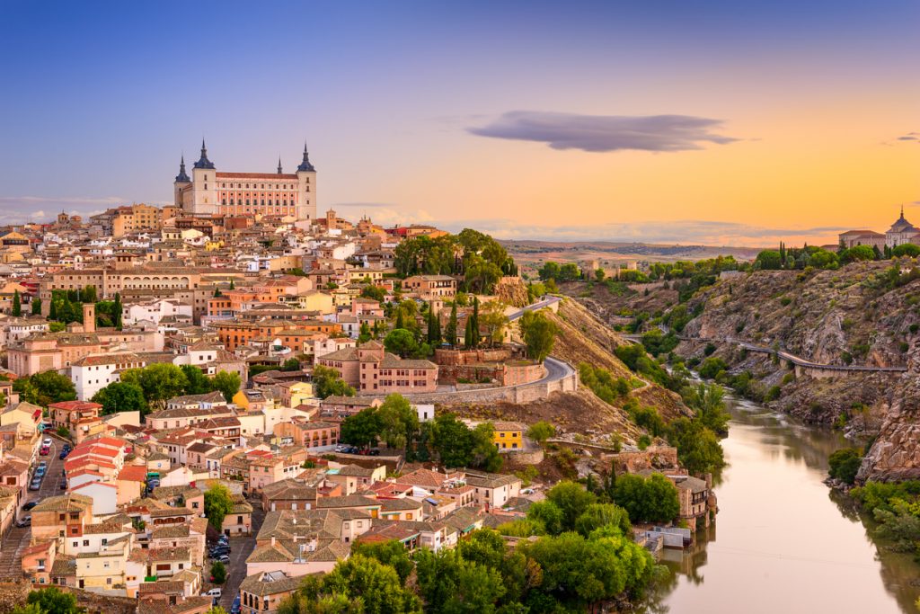 Weitblick über die Altstadt von Toledo mit dem Alcázar und der Schlucht des Tajo in goldenem Abendlicht.