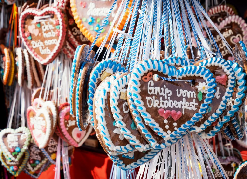 Bunte Lebkuchenherzen mit weiß-blauen Bordüren hängen dicht aneinander.