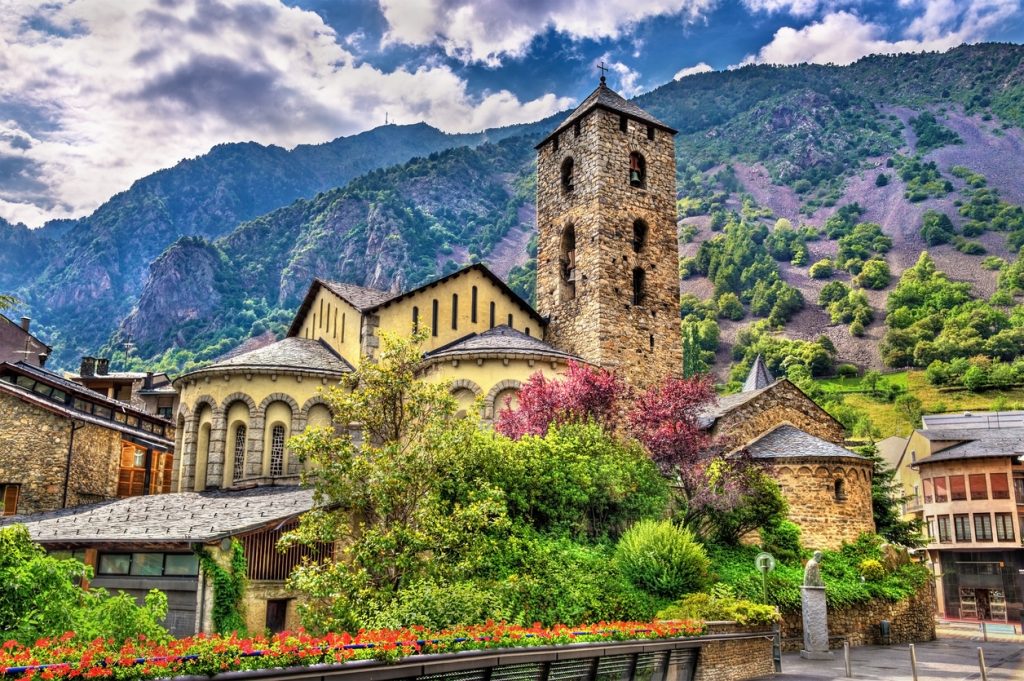 Steinkirche mit quadratischem Turm und Garten in Andorra la Vella.