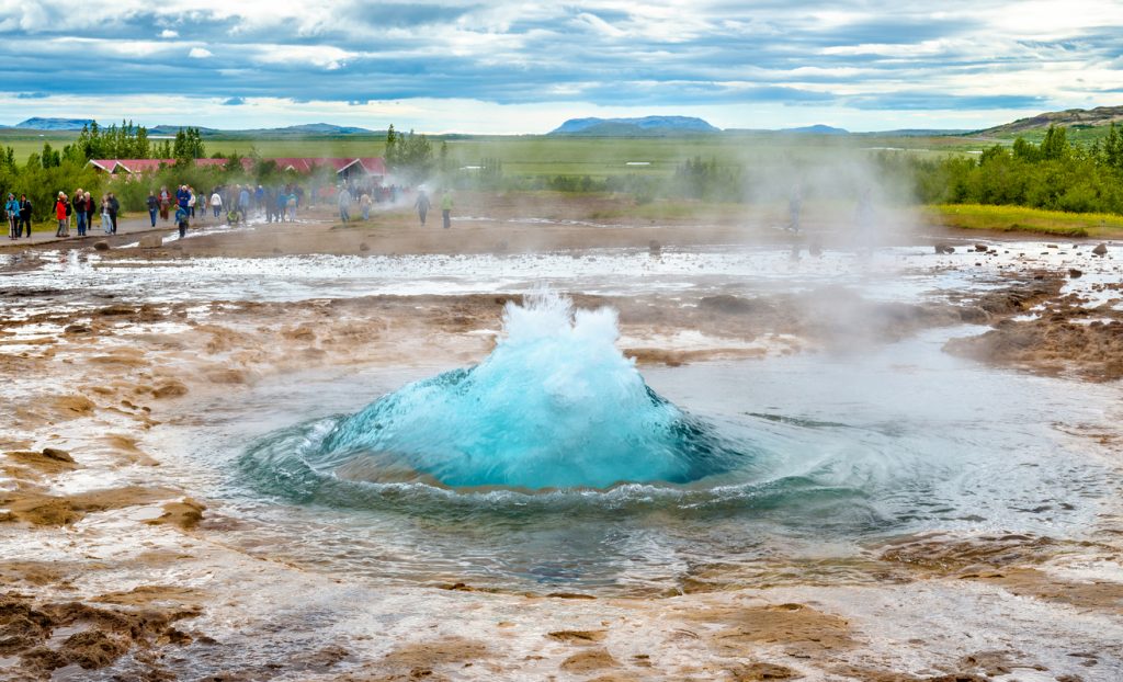 Kurz vor dem Ausbruch wölbt sich die türkisfarbene Wasserblase des Geysirs Strokkur im Golden Circle.