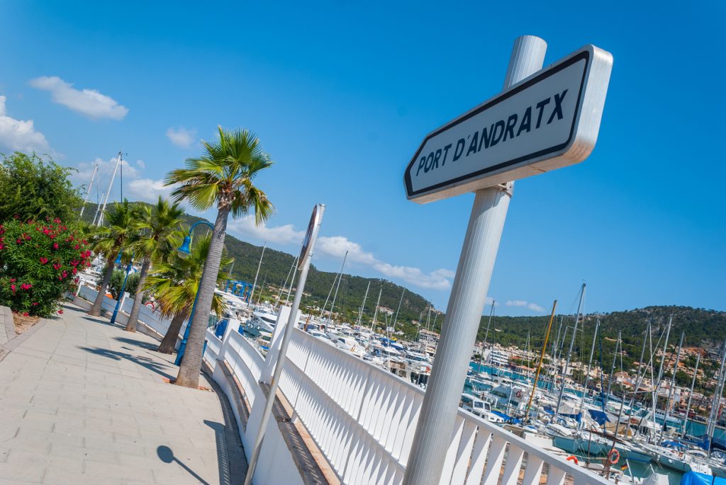Weg mit Palmen und Schild „Port d’Andratx“ entlang der Marina.