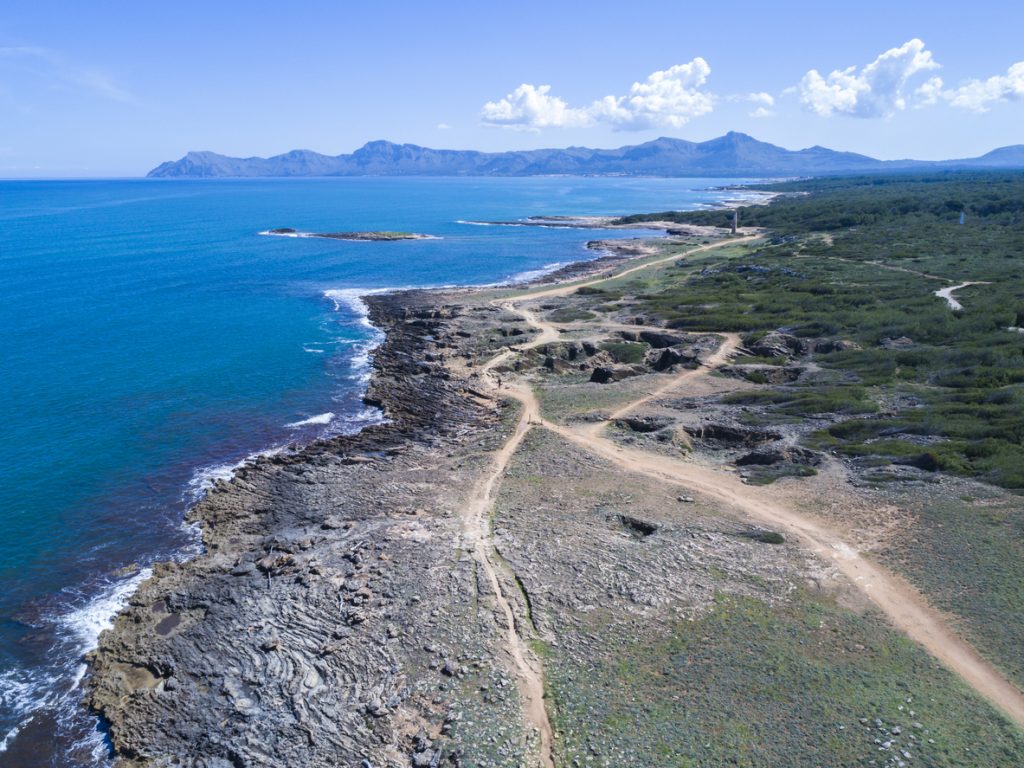 Felsige Küste mit Wanderwegen und tiefblauem Meer bei Santa Margalida.