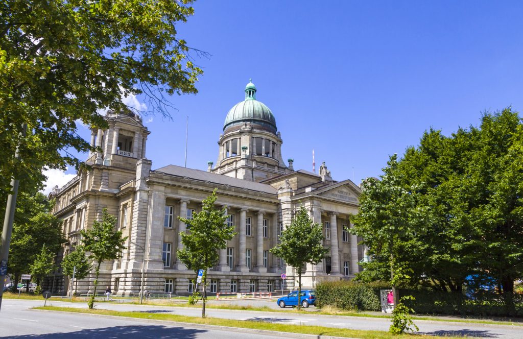 Ein klassisches Gebäude mit grüner Kuppel steht in Hamburg an einer breiten Straße.